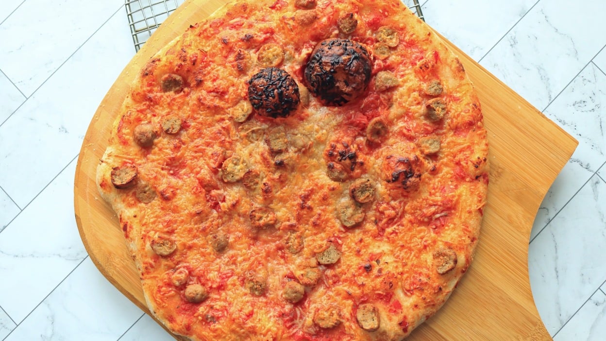 Pizza on a wooden pizza peel.