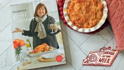 Go-To Dinners cookbook on a table next to mac and cheese and an oven mitt.