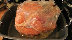 A turkey in a roasting bag in a roasting pan.