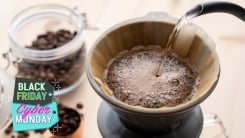 A kettle pouring water over coffee grounds in a filter.